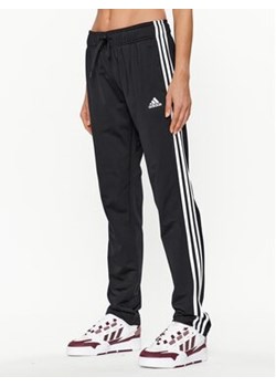 adidas Spodnie dresowe Essentials Warm-Up 3-Stripes H48451 Czarny Regular Fit ze sklepu MODIVO w kategorii Spodnie damskie - zdjęcie 168607301