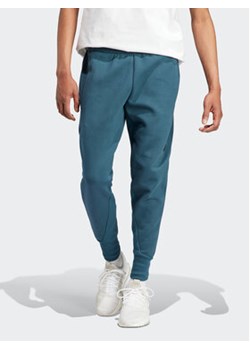 adidas Spodnie dresowe IN5100 Turkusowy Regular Fit ze sklepu MODIVO w kategorii Spodnie męskie - zdjęcie 168610782