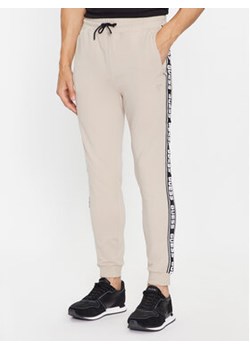Guess Spodnie dresowe Z2YB19 K6ZS1 Beżowy Regular Fit ze sklepu MODIVO w kategorii Spodnie męskie - zdjęcie 168615181