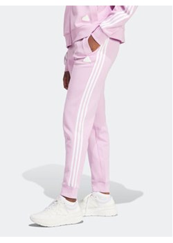 adidas Spodnie dresowe Future Icons 3-Stripes IM2546 Różowy Regular Fit ze sklepu MODIVO w kategorii Spodnie damskie - zdjęcie 168626262
