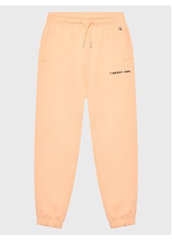 Calvin Klein Jeans Spodnie dresowe Logo IG0IG01509 Pomarańczowy Relaxed Fit ze sklepu MODIVO w kategorii Spodnie dziewczęce - zdjęcie 168633164