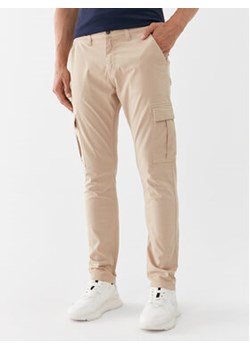 Guess Spodnie materiałowe M2GB27 WCNZ0 Beżowy Slim Fit ze sklepu MODIVO w kategorii Spodnie męskie - zdjęcie 168651140