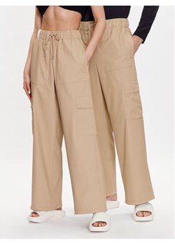 Rains Spodnie materiałowe 18990 Beżowy Comfortable Fit ze sklepu MODIVO w kategorii Spodnie damskie - zdjęcie 168651394