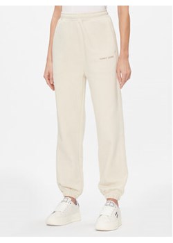 Tommy Jeans Spodnie dresowe Classics DW0DW17309 Beżowy Relaxed Fit ze sklepu MODIVO w kategorii Spodnie damskie - zdjęcie 168660171