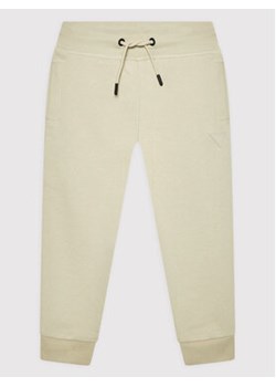 Guess Spodnie dresowe L2YQ46 KAIJ1 Beżowy Regular Fit ze sklepu MODIVO w kategorii Spodnie chłopięce - zdjęcie 168673052