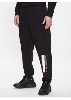 Calvin Klein Jeans Spodnie dresowe J30J323504 Czarny Regular Fit ze sklepu MODIVO w kategorii Spodnie męskie - zdjęcie 168678320