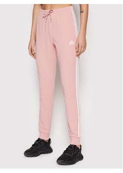 adidas Spodnie dresowe Essentials HD4272 Różowy Slim Fit ze sklepu MODIVO w kategorii Spodnie damskie - zdjęcie 168678701