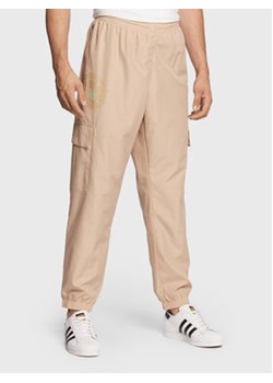 adidas Spodnie dresowe Ozworld HL9251 Beżowy Regular Fit ze sklepu MODIVO w kategorii Spodnie męskie - zdjęcie 168689683