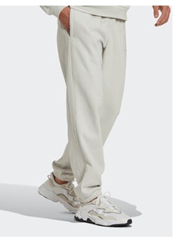 adidas Spodnie dresowe Reveal Essentials HK2728 Beżowy Regular Fit ze sklepu MODIVO w kategorii Spodnie męskie - zdjęcie 168734544