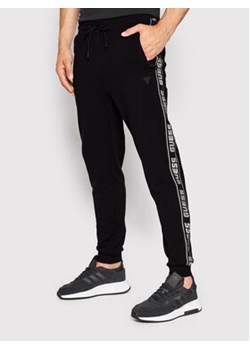 Guess Spodnie dresowe Z2YB19 K6ZS1 Czarny Regular Fit ze sklepu MODIVO w kategorii Spodnie męskie - zdjęcie 168747114
