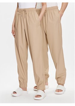 Rains Spodnie materiałowe Unisex 18560 Beżowy Comfortable Fit ze sklepu MODIVO w kategorii Spodnie damskie - zdjęcie 169288520
