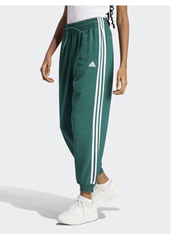 adidas Spodnie dresowe Essentials 3-Stripes French Terry Loose-Fit Joggers IL3448 Zielony Loose Fit ze sklepu MODIVO w kategorii Spodnie damskie - zdjęcie 169373493