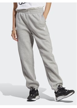 adidas Spodnie dresowe Essentials Fleece IA6432 Szary Regular Fit ze sklepu MODIVO w kategorii Spodnie damskie - zdjęcie 169423351