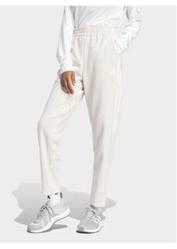 adidas Spodnie dresowe Train Essentials IS3969 Różowy Loose Fit ze sklepu MODIVO w kategorii Spodnie damskie - zdjęcie 169491723