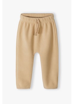 Beżowe spodnie dresowe niemowlęce ze sklepu 5.10.15 w kategorii Spodnie i półśpiochy - zdjęcie 169703902