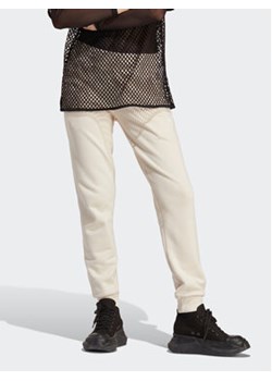 adidas Spodnie dresowe adicolor Essentials IA6477 Beżowy Slim Fit ze sklepu MODIVO w kategorii Spodnie damskie - zdjęcie 169895584