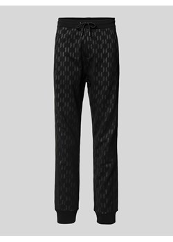 Spodnie dresowe o kroju regular fit z nadrukiem z logo na całej powierzchni ze sklepu Peek&Cloppenburg  w kategorii Spodnie męskie - zdjęcie 170396272
