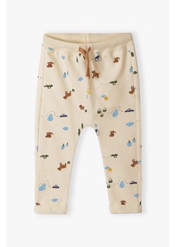 Beżowe bawełniane spodnie dresowe niemowlęce z nadrukiem ze sklepu 5.10.15 w kategorii Spodnie i półśpiochy - zdjęcie 170492960