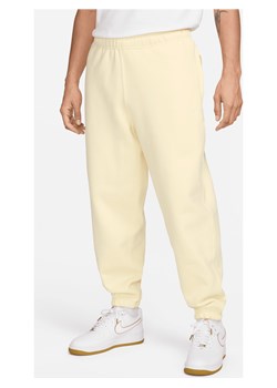 Męskie spodnie z dzianiny Nike Solo Swoosh - Brązowy ze sklepu Nike poland w kategorii Spodnie męskie - zdjęcie 170914551
