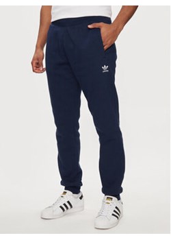 adidas Spodnie dresowe Trefoil Essentials IR7804 Granatowy Slim Fit ze sklepu MODIVO w kategorii Spodnie męskie - zdjęcie 171343252