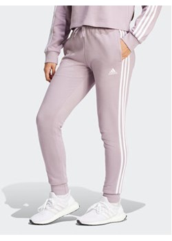 adidas Spodnie dresowe Essentials 3-Stripes IR5379 Różowy Slim Fit ze sklepu MODIVO w kategorii Spodnie damskie - zdjęcie 171377722