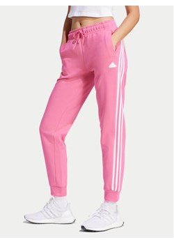 adidas Spodnie dresowe Future Icons 3-Stripes IS3942 Różowy Regular Fit ze sklepu MODIVO w kategorii Spodnie damskie - zdjęcie 171507964