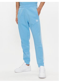 adidas Spodnie dresowe adicolor 3-Stripes IM9451 Niebieski Slim Fit ze sklepu MODIVO w kategorii Spodnie męskie - zdjęcie 171953691
