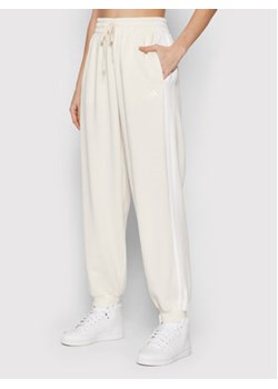 adidas Spodnie dresowe Essentials Studio Lounge 3-Stripes HD4305 Biały Loose Fit ze sklepu MODIVO w kategorii Spodnie damskie - zdjęcie 171963520