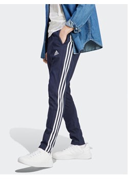 adidas Spodnie dresowe Essentials IC0045 Granatowy Regular Fit ze sklepu MODIVO w kategorii Spodnie męskie - zdjęcie 172370612