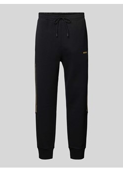 Spodnie dresowe o kroju tapered fit z detalem z logo model ‘Hadikonos’ ze sklepu Peek&Cloppenburg  w kategorii Spodnie męskie - zdjęcie 172540554