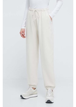 New Balance spodnie dresowe bawełniane WP41513LIN kolor beżowy gładkie ze sklepu PRM w kategorii Spodnie damskie - zdjęcie 173802862