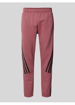 Spodnie dresowe o kroju slim fit z charakterystycznymi dla marki paskami ze sklepu Peek&Cloppenburg  w kategorii Spodnie męskie - zdjęcie 173887524