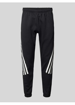 Spodnie dresowe o kroju regular fit z charakterystycznymi dla marki paskami ze sklepu Peek&Cloppenburg  w kategorii Spodnie męskie - zdjęcie 174372792