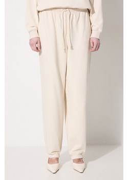 New Balance spodnie dresowe bawełniane WP41513LIN kolor beżowy gładkie ze sklepu PRM w kategorii Spodnie damskie - zdjęcie 174671223