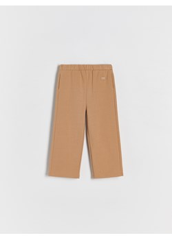 Reserved - Bawełniane spodnie z naszywką - beżowy ze sklepu Reserved w kategorii Spodnie dziewczęce - zdjęcie 176366792