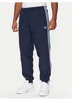 adidas Spodnie dresowe adicolor Firebird JP1249 Granatowy Regular Fit ze sklepu MODIVO w kategorii Spodnie męskie - zdjęcie 176664232