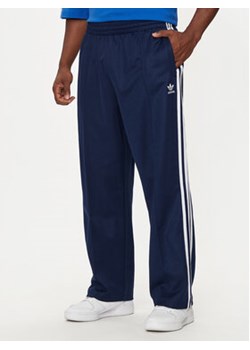 adidas Spodnie dresowe adicolor Firebird IZ2466 Granatowy Baggy Fit ze sklepu MODIVO w kategorii Spodnie męskie - zdjęcie 176982194