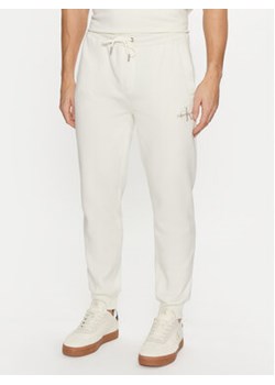 Calvin Klein Jeans Spodnie dresowe Monologo Hwk Pant J30J325658 Écru Regular Fit ze sklepu MODIVO w kategorii Spodnie męskie - zdjęcie 177030330