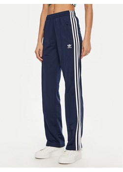 adidas Spodnie dresowe adicolor Classics Firebird JC8285 Granatowy Regular Fit ze sklepu MODIVO w kategorii Spodnie damskie - zdjęcie 181093630
