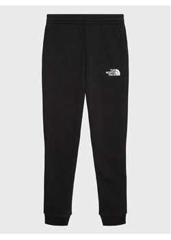 The North Face Spodnie dresowe Teen NF0A82EO Czarny Regular Fit ze sklepu MODIVO w kategorii Spodnie chłopięce - zdjęcie 181123010