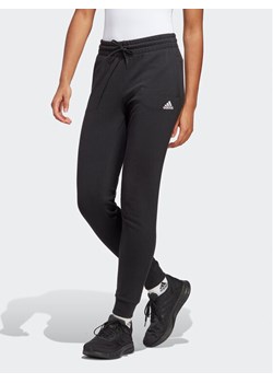 adidas Spodnie dresowe Essentials Linear French Terry Cuffed Joggers IC6868 Czarny Slim Fit ze sklepu MODIVO w kategorii Spodnie damskie - zdjęcie 181124711