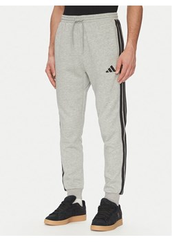 adidas Spodnie dresowe Essentials 3-Stripes JE6318 Szary Regular Fit ze sklepu MODIVO w kategorii Spodnie męskie - zdjęcie 181130394