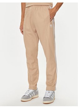 adidas Spodnie dresowe adicolor Classics Beckenbauer IZ1857 Beżowy Slim Fit ze sklepu MODIVO w kategorii Spodnie męskie - zdjęcie 181134182