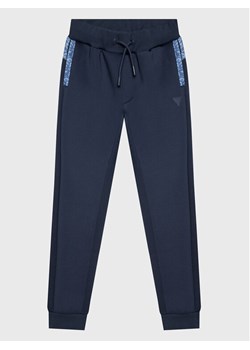 Guess Spodnie dresowe L3RQ15 JR06W Niebieski Relaxed Fit ze sklepu MODIVO w kategorii Spodnie chłopięce - zdjęcie 181134941