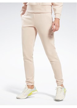 Reebok Spodnie dresowe Fleece IC3502 Beżowy Slim Fit ze sklepu MODIVO w kategorii Spodnie damskie - zdjęcie 181141451