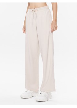 Tommy Hilfiger Spodnie dresowe UW0UW04771 Beżowy Relaxed Fit ze sklepu MODIVO w kategorii Spodnie damskie - zdjęcie 181149551
