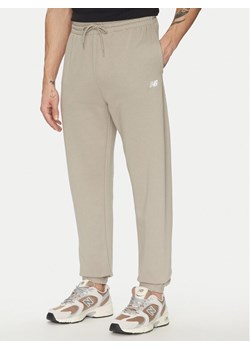 New Balance Spodnie dresowe Essentials MP41519 Beżowy Relaxed Fit ze sklepu MODIVO w kategorii Spodnie męskie - zdjęcie 181150451