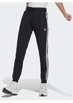 adidas Spodnie dresowe Adicolor Classics Slim Cuffed Joggers IB7455 Czarny Slim Fit ze sklepu MODIVO w kategorii Spodnie męskie - zdjęcie 181151360