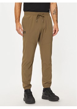 Under Armour Spodnie dresowe UA Vibe Woven 1386557 Brązowy Regular Fit ze sklepu MODIVO w kategorii Spodnie męskie - zdjęcie 181157254