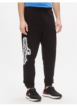 Tommy Jeans Spodnie dresowe Tjm Reg Tommy Spray Sweatpant DM0DM18376 Czarny Regular Fit ze sklepu MODIVO w kategorii Spodnie męskie - zdjęcie 181157400